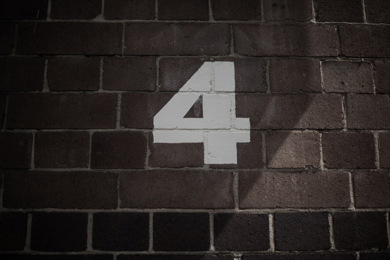 The number four is painted on the brick wall