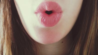 A person puckers her lips to whistle.