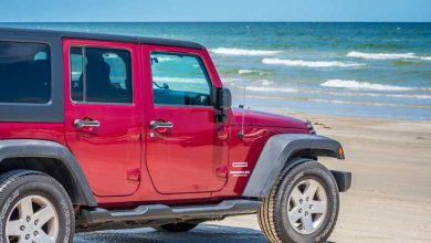 Red Jeep Wrangler Unlimited Sport Parked on the Beach