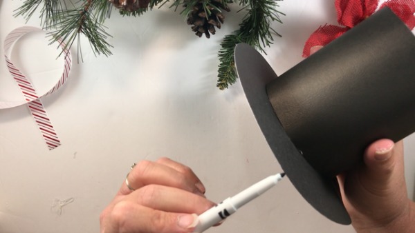 Use a black marker to cover the white edges of your DIY snowman hat