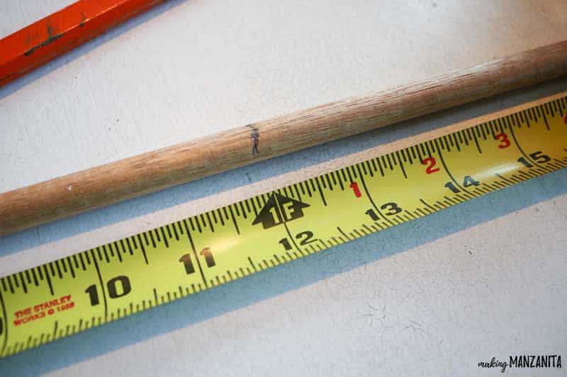 Measure the wooden dowel and mark 12 inches for the center of the mini Christmas tree with the tie fabric