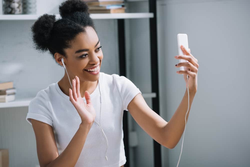 Young black girl taking a selfie with thick curly short hair on both sides