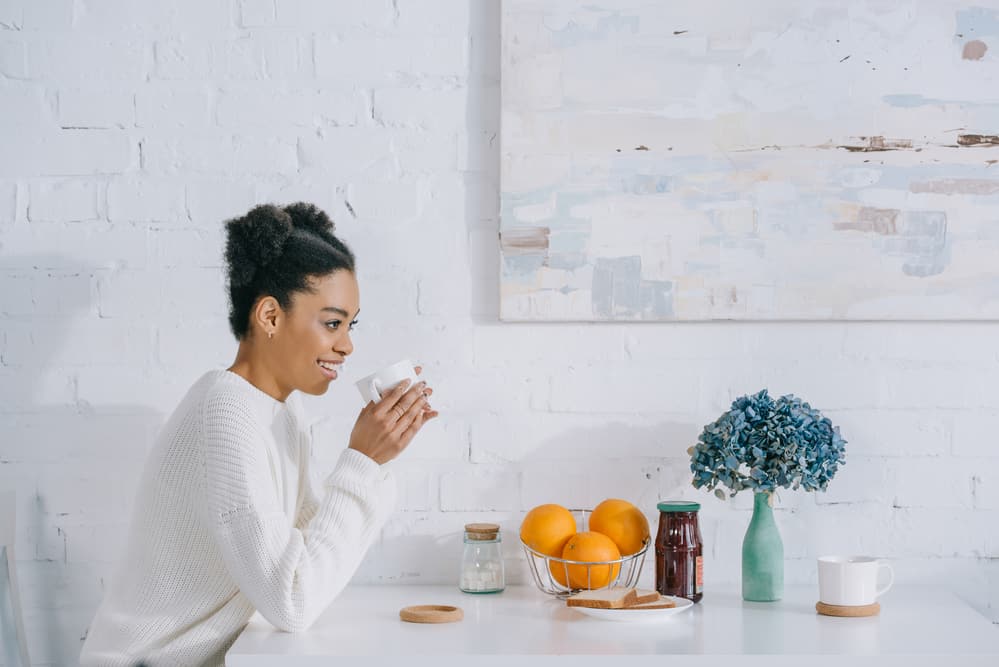 Woman drinking coffee at breakfast with curly hair