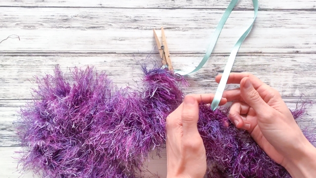 tie the yarn to the ribbon to complete the lei