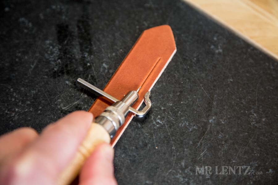 making a decorative line in a leather axe sheath