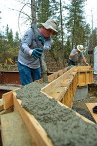 The Fords ordered a concrete pump to pour the bridge footings and then later the bridge headers. They could have done the job with standard concrete truck chutes on the road side of the bridge, but they definitely needed the concrete pump to move the material to the footings on the other side of the creek.