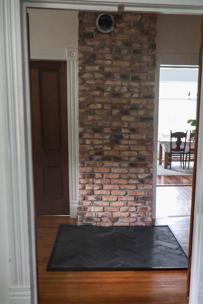 front view of a brick chimney with a do-it-yourself fireplace mantel from slate in a backbone pattern
