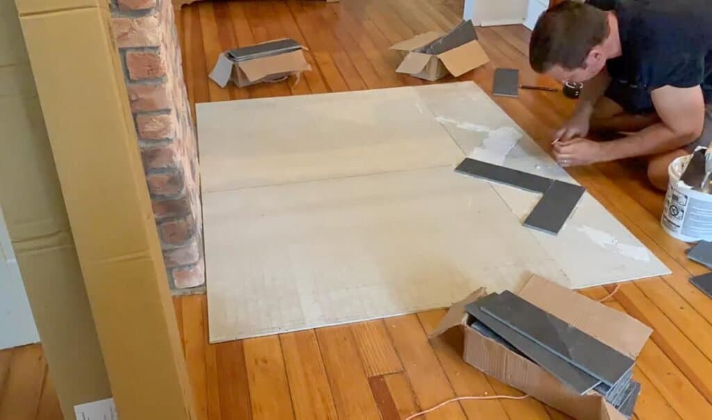 man placing herringbone-shaped black slate