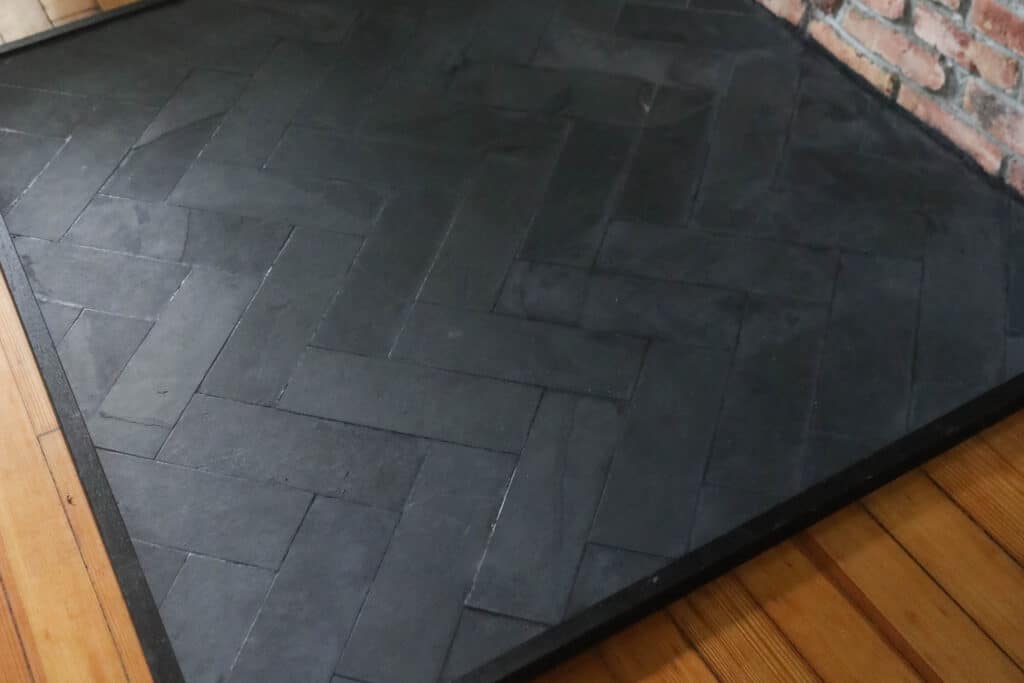 Close-up image of a homemade slate fireplace pad in herringbone pattern