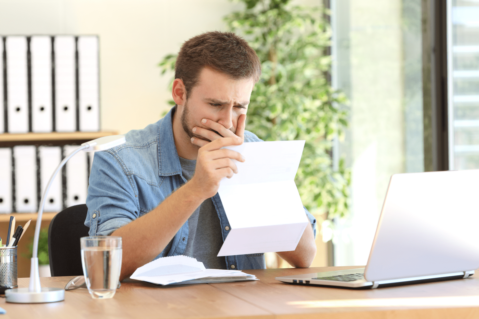 a man sits at a table and reads a letter