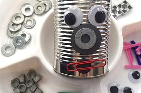 Tin box with face made from googly eyes, washers and cardboard.