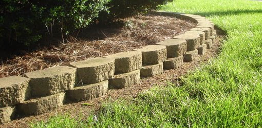 Straw mulch layer behind block retaining wall.