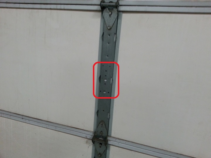 A arranger locks the garage door into the center holes of the column.