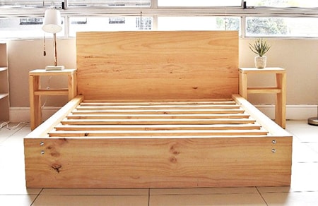 the wooden bed frame reaches the floor to eliminate the need for bed skirts