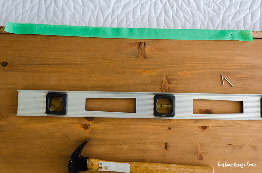 The masking tape on the top of the picture has 2 holes where the hangers need to be placed.