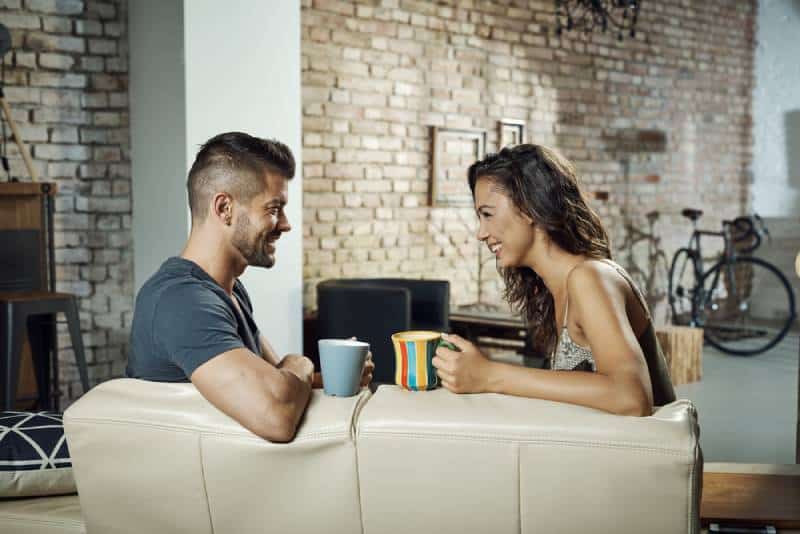 couple sitting in living room and talking over coffee
