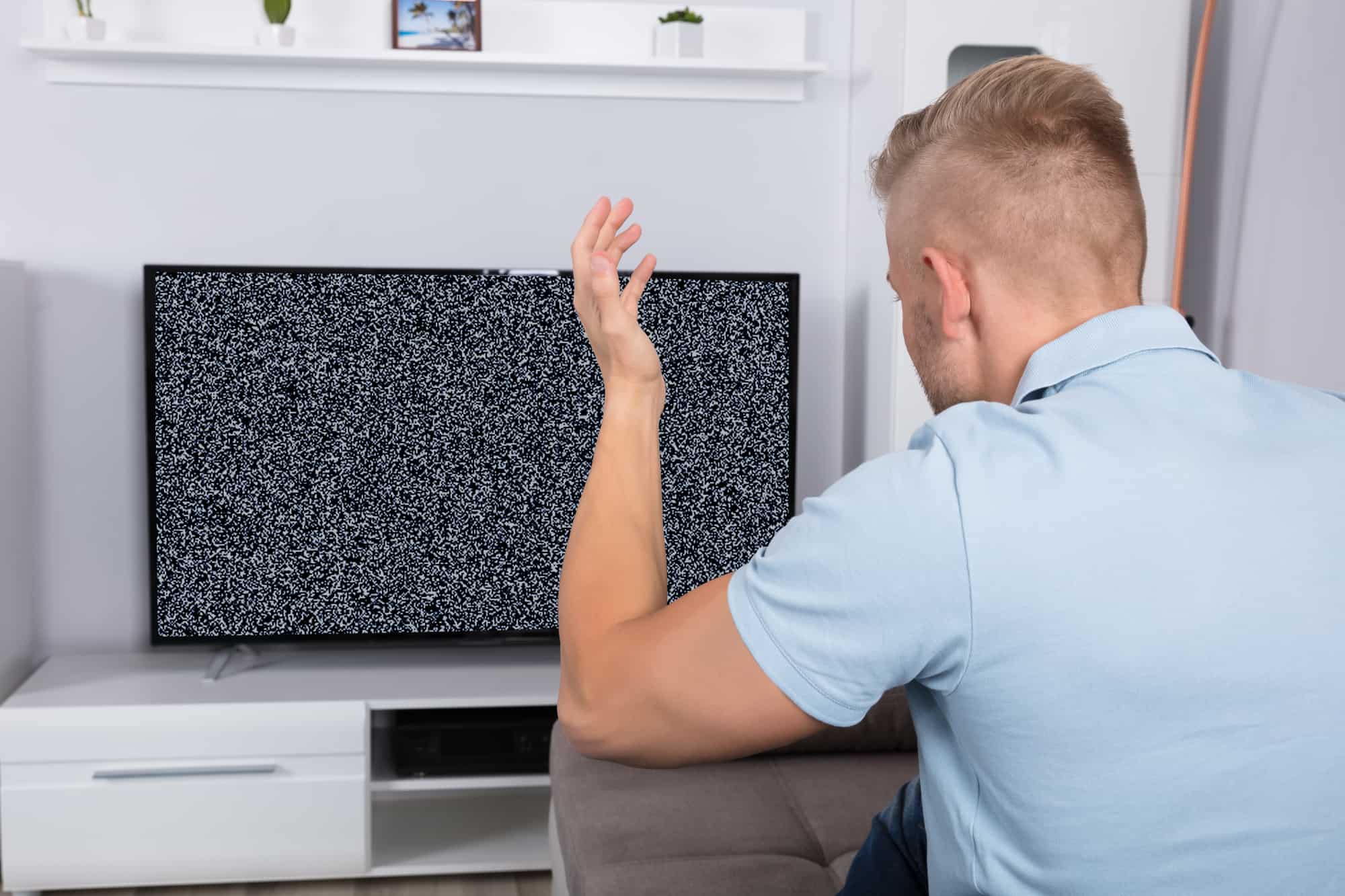 Blond man in blue polo shirt not getting cable TV