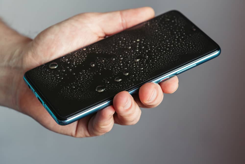 man holds wet phone in his hand