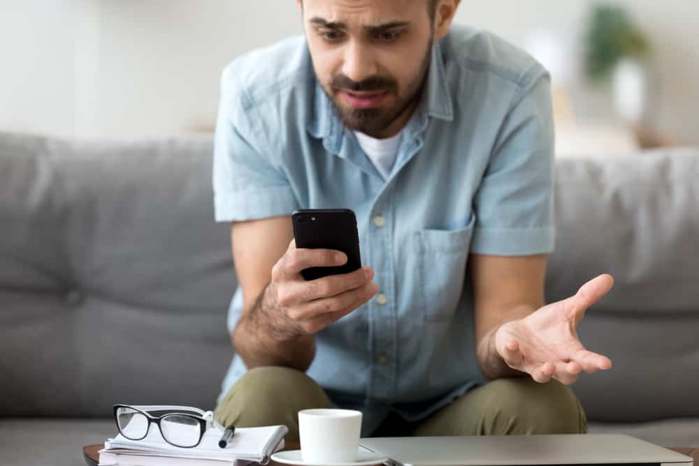 Close up confused man having problem with broken not working phone