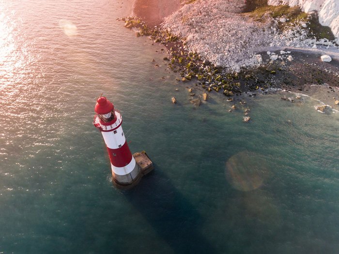 Aerial shot of the lighthouse on the coast with flare lens