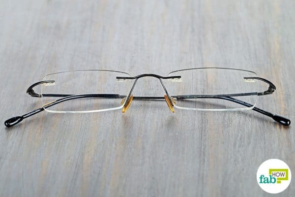 Remove glue from eyeglasses using warm water and toothpaste