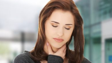 woman with sore throat holding neck