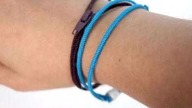 Student wearing blue and black bracelets made of zippers