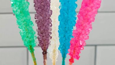 Close-up of 5 different colors rock candy in mason jar with