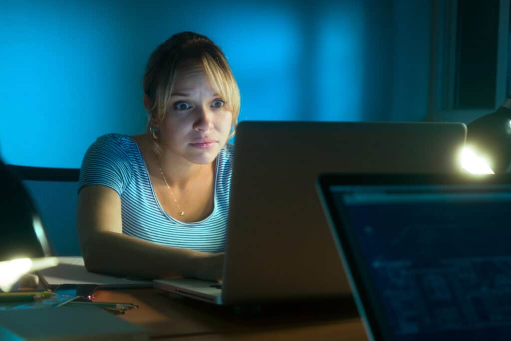 Woman reading creepy messages on social media late at night