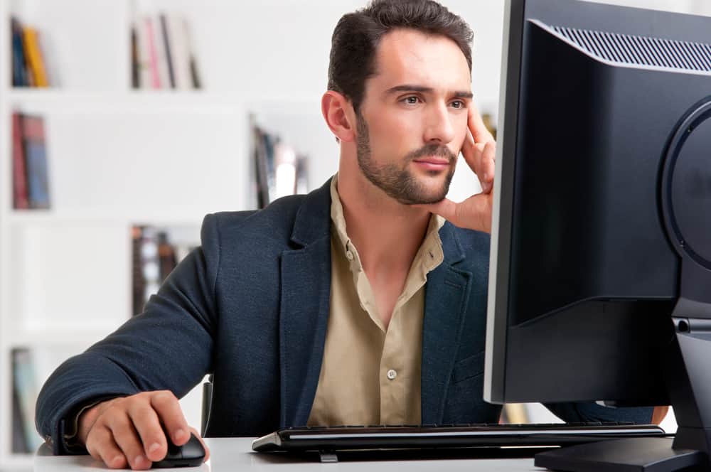 Man looking at a computer screen, thinking