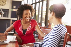 Two female friends talking at a cafe