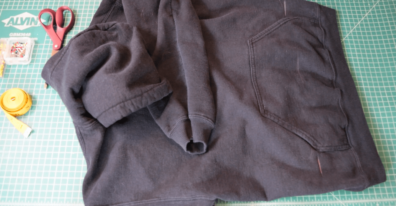 black hoodie on carpet cut with chalk marks on the sides of the pockets