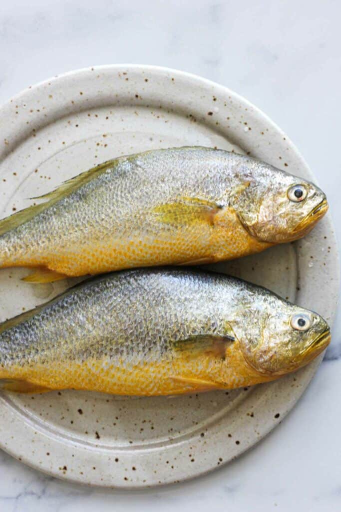 on the plate two yellow croaker fish