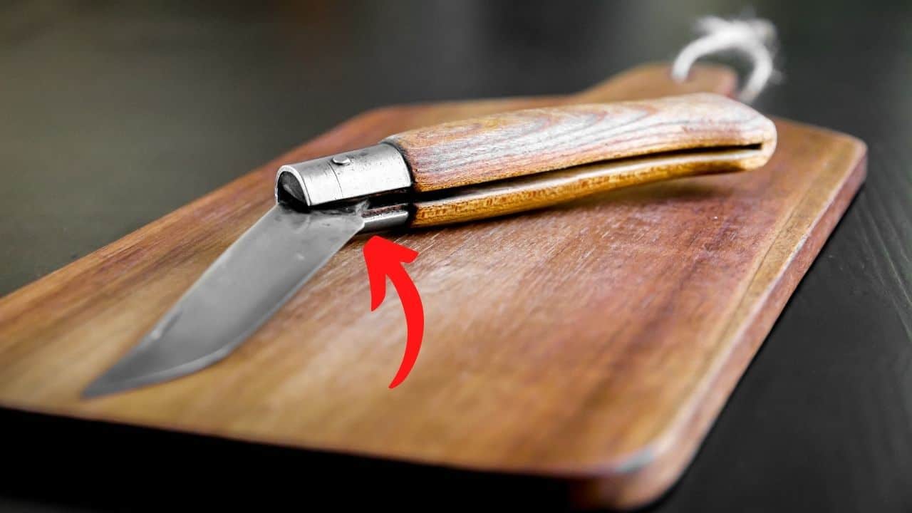 slip joint folding knife with a red arrow pointing to the release