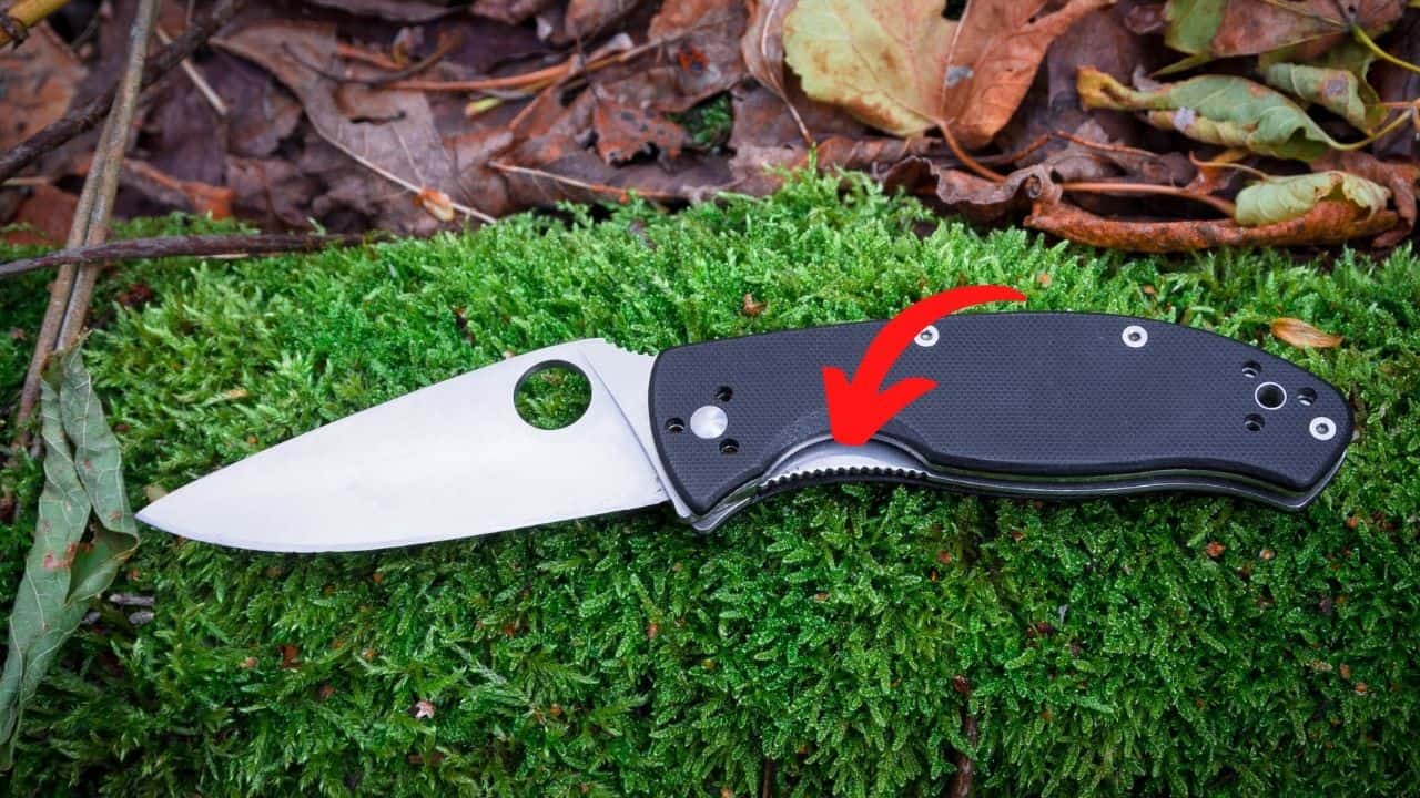 frame lock folding knife with a red arrow pointing to the release