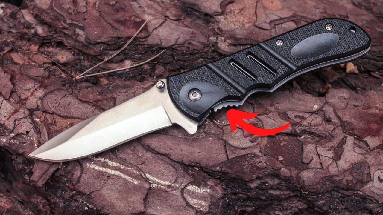 liner lock folding knife with a red arrow pointing to the release