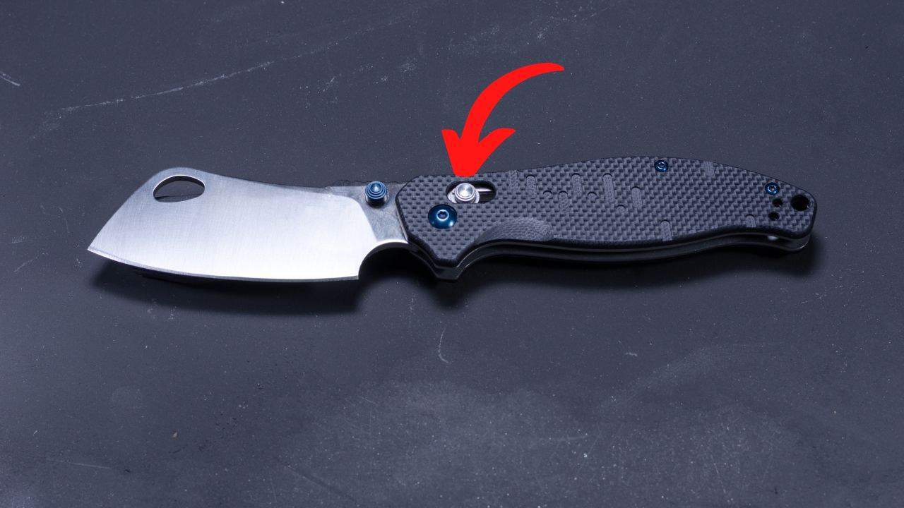 axis lock folding knife with a red arrow pointing to the release