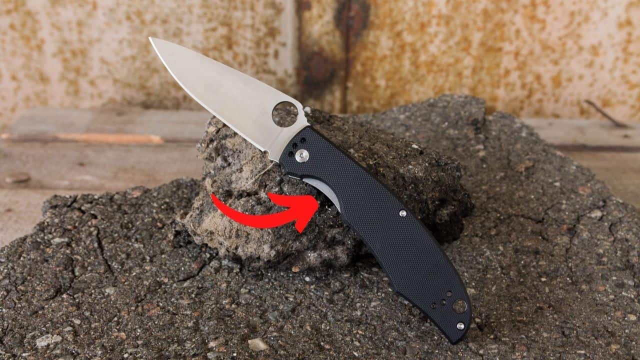 compression lock folding knife with a red arrow pointing to the release