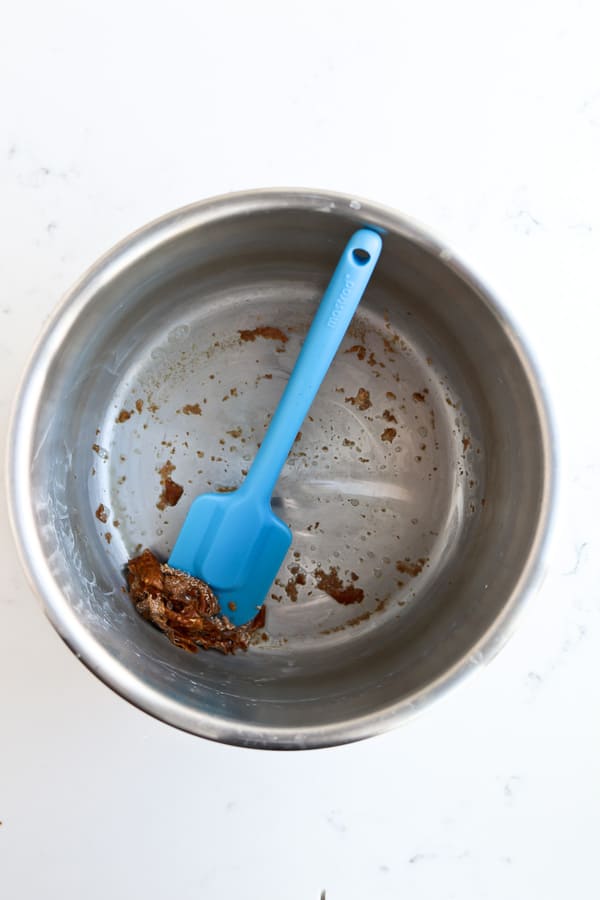 A blue spoon in a pot instantly scrapes the burnt mess