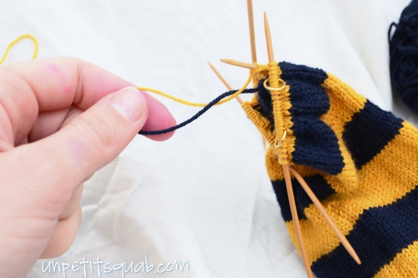 Wrap the working yarn anti-clockwise once around the yarn being carried.