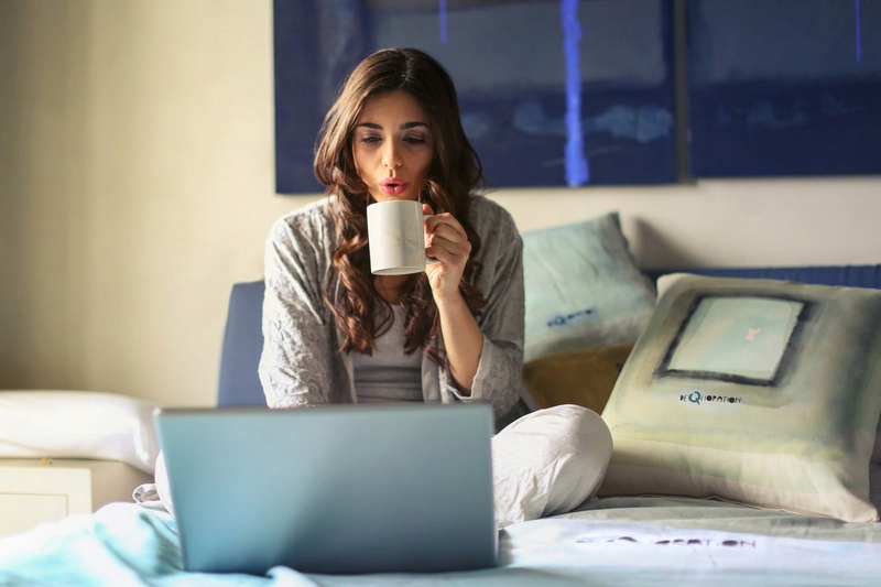 woman drinking coffee and working at home