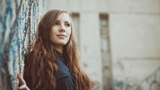 Confident woman leaning against the wall