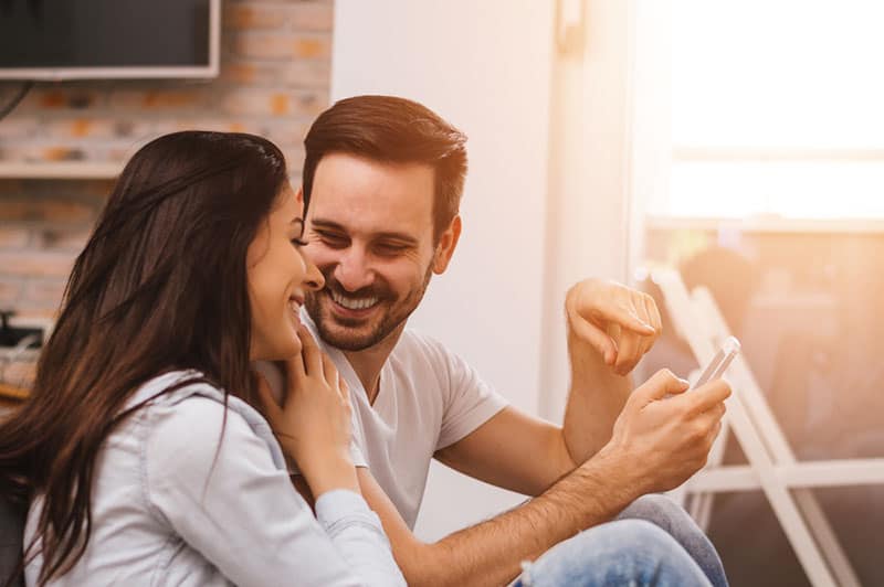 Young Couple sitting on the floor and looking at each other.