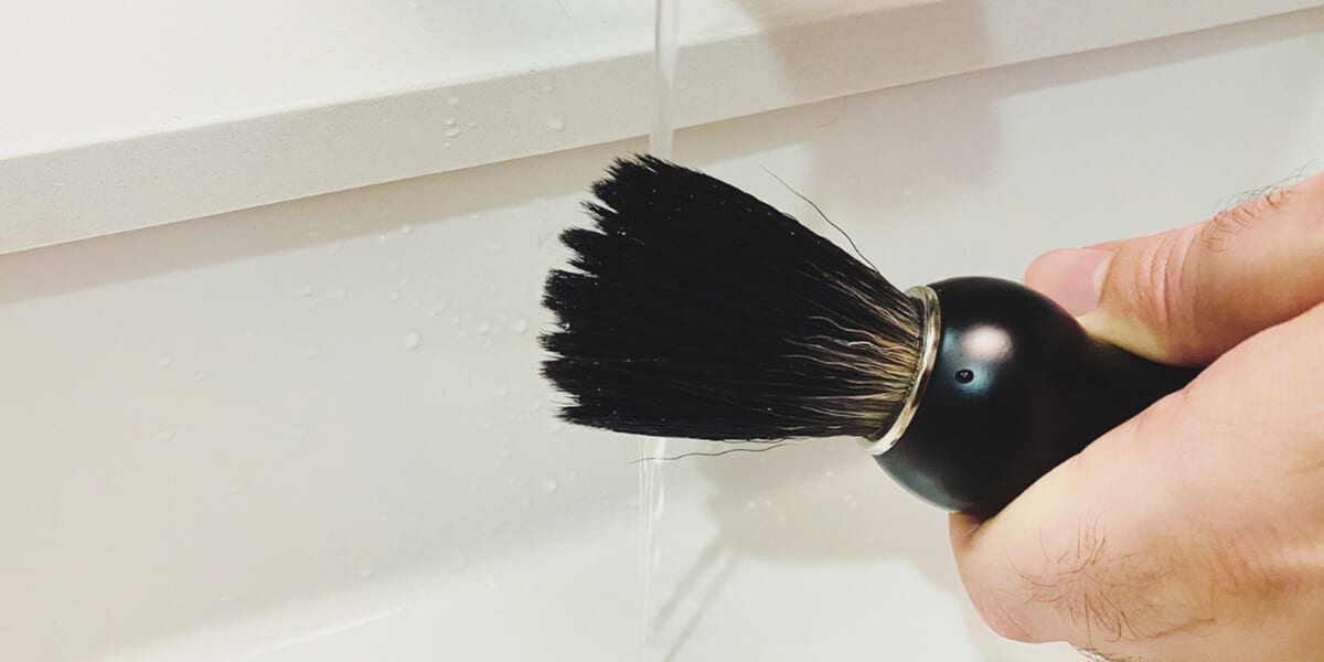 rinsing beard brush in bathroom sink