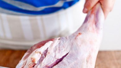 Image of carefully cutting down the lamb leg to expose the bone
